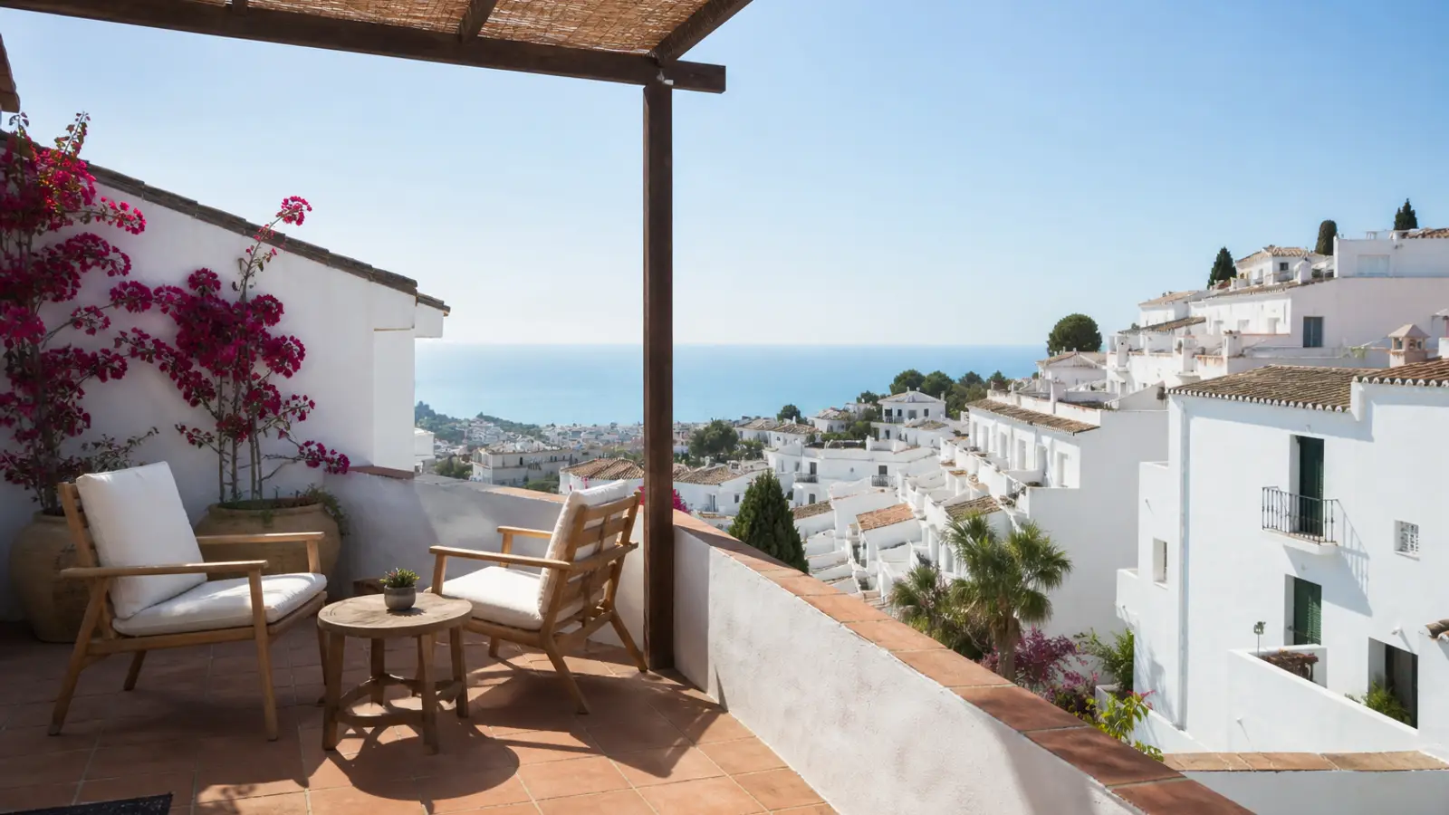 Azotea de casa blanca en Frigiliana con pérgola y vistas al pueblo y al mar